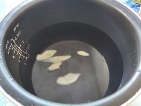 电饭煲加入适量水，我一般是三个人五饭碗的水，加几片姜开始煮水。