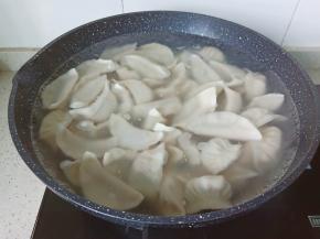 锅中水下入饺子，用铲子顺锅沿和锅底将水饺轻轻铲起，防止粘锅。