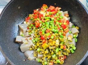 放入切好的酸豇豆，泡椒，青红尖椒翻炒均匀！