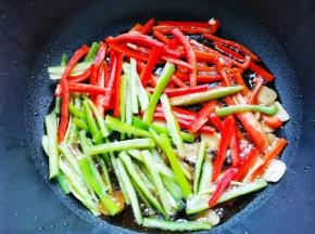 锅内热油下蒜片爆香，加辣椒丝炒至7分熟，