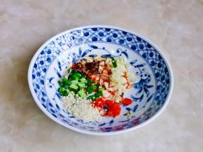 准备做酸汤，葱蒜切碎放入碗中，加入小米辣，油泼辣子，熟白芝麻。