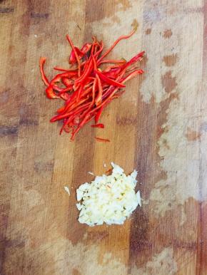 红辣椒去蒂去籽切成丝，蒜瓣拍碎剁成碎末备用！