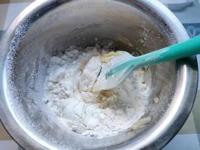 黄油中的糖融化后，先后筛入低筋面粉和玉米淀粉，先用刮刀拌到没有干粉。