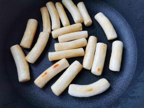 年糕提前凉水泡开。热锅适量油，放入年糕煎至两面金黄，