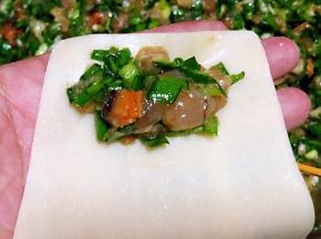 取适量的馅料放入馄饨皮一端的中间