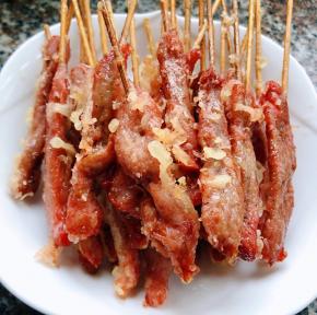 炸好的香酥牛肉串发入盘中沥油备用