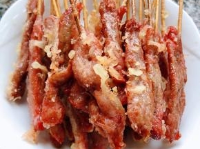 炸好的香酥牛肉串发入盘中沥油备用