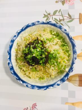 面碗中放入焯水的绿豆芽，再放两大勺刚刚熬好的炸酱，撒上适量的葱花！（也可以把绿豆芽换成自己喜欢吃的配菜，比如：黄瓜丝，胡萝卜丝……）