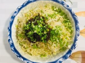 面碗中放入焯水的绿豆芽，再放两大勺刚刚熬好的炸酱，撒上适量的葱花！（也可以把绿豆芽换成自己喜欢吃的配菜，比如：黄瓜丝，胡萝卜丝……）