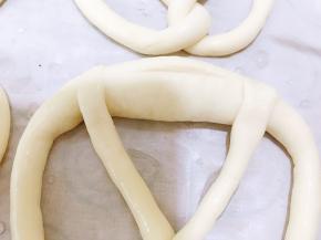 泡好碱水后放在铺有油纸的烤盘里，迅速割包