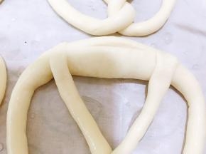 泡好碱水后放在铺有油纸的烤盘里，迅速割包
