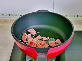 起油锅，加入蒜末煸炒，再加入香肠。