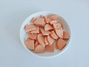 香肠剥皮外衣，对半切开再切小块，不能切太薄，容易碎。