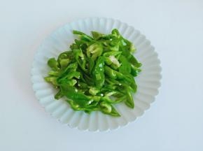 青椒去除蒂部，里面的籽也清洗干净，对半切开再切成丝。