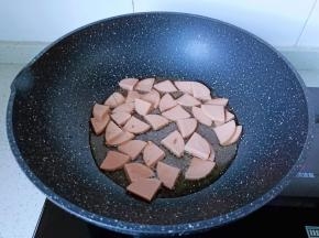 热锅凉油下蒜泥炒香，再放入香肠翻炒。