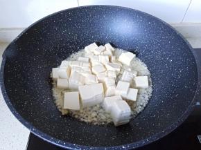 热锅凉油爆香蒜泥，下豆腐块。
