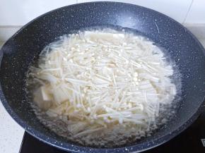 豆腐炖煮一会儿后加入金针菇。