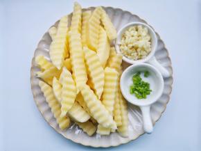 准备好所有食材。土豆洗净去皮切厚片，再用狼牙刀切成条，泡水5分钟清洗掉多余的淀粉。葱蒜切末。