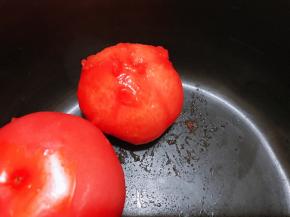 西红柿顶部划十字，用开水烫皮后剥去外皮