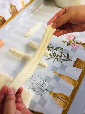 捏住两头，轻轻地抻一下，油条生胚就做好了！