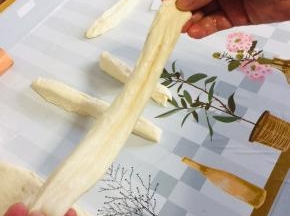 捏住两头，轻轻地抻一下，油条生胚就做好了！