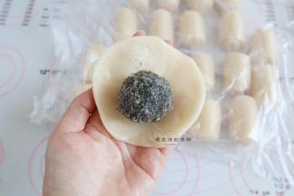 擀好的面剂取一个压扁擀开，包入芝麻核桃馅，团起来捏紧收口，要是收口难粘住，可以沾少许的清水协助。