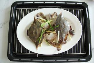 放在蒸架上，梭子蟹上放好部分葱段和姜丝！