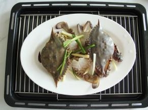 放在蒸架上，梭子蟹上放好部分葱段和姜丝！