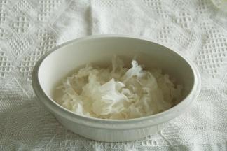 将撕开的银耳放入炖盅里。