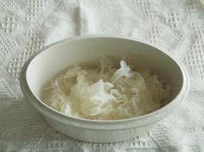 将撕开的银耳放入炖盅里。