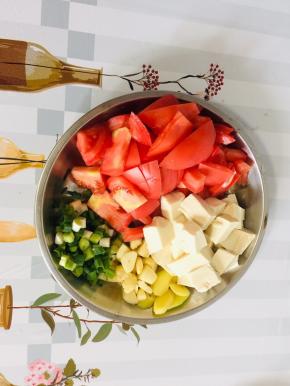 西红柿洗净切成片，嫩豆腐切成小块，生姜切成片，蒜瓣对半切开，葱切成葱花备用！