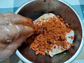 取一个大碗，放入1个鸡腿，加入1汤匙料酒，再加入一种烤翅料，用手搓揉一会。