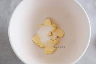 将软化的黄油放入揉面盆里，倒入细砂糖搅拌一下。