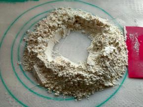 把筛好的面粉倒在面垫上，可预留出少许面粉调整硬度，然后把面粉堆成小山坡，中间掏空。