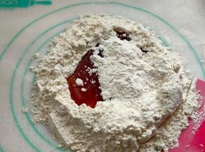 把第二部做好的液体倒入，用刮板一点点把面粉撒入，慢慢融合，直至慢慢融合成一块面团。