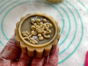 月饼模扣在圆球上，速度且大力的两下压出月饼花纹，马上抬起模子，就完成了。