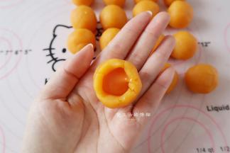 奶黄馅滚圆后从中间戳一个洞，挤入一半高度的流心馅，慢慢收口起来，因为是液体的，容易爆馅，所以馅不能挤太多，要是自己做的流心，可以冷动硬了再包。