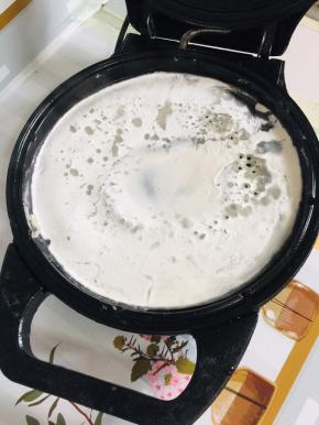 电饼铛提前预热，刷少许油，倒入两大勺粉浆！烙至凝固定型！