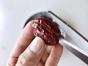 用剪刀把红枣剪开，剪一边即可。