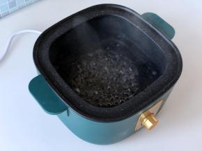 在生活元素蒸煮锅里加入适量清水，开大火煮开。