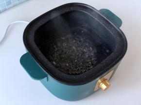 在生活元素蒸煮锅里加入适量清水，开大火煮开。