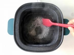 蒸煮锅里留100克左右的热水，加入两勺白砂糖，加热两三分钟煮成糖水。