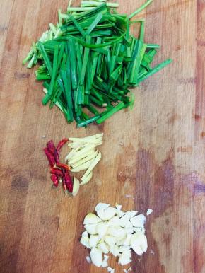 韭菜洗净切成段，干辣椒切段，生姜切丝，蒜瓣拍碎切丁备用！