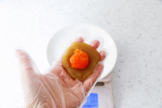 把白莲蓉按扁放入蛋黄