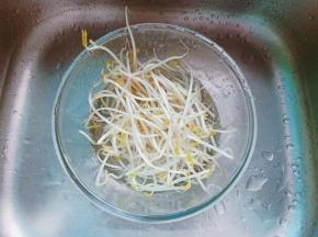 将豆芽放入碗里，加满水用手轻轻搅动，没有脱落的豆芽皮就漂浮在水面上，然后用手捞出，豆芽的根本也可以择去。