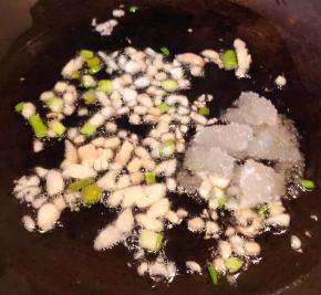 锅中倒入底油加热放入葱姜蒜爆香再放入糖炒匀