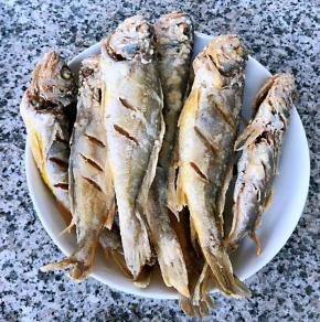 炸好的黄鱼放入盘中控油