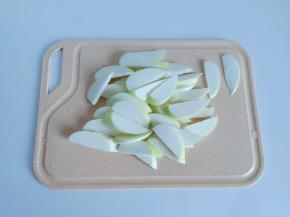 茭白剥去外壳，清洗好后对半切开，切成薄片。