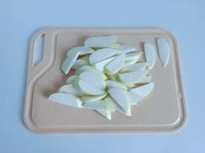 茭白剥去外壳，清洗好后对半切开，切成薄片。