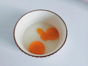 碗里打入两个鸡蛋。